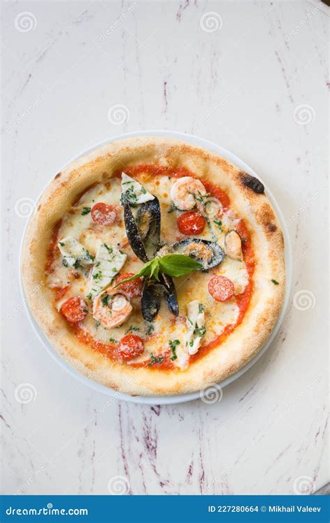 Whole Neapolitan Seafood Pizza Served On A Marble Table Stock Photo