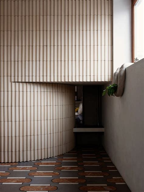 An Empty Room With Wooden Slats On The Wall And Tiled Floor In Front Of It