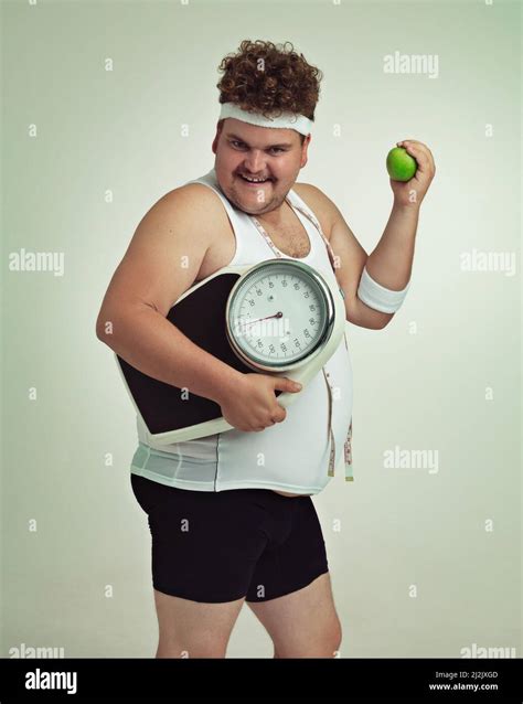 Lets Do This Cropped Shot Of An Overweight Man Holding A Applescale