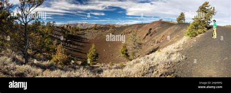 A male hiker standing above a small crater along the Tree Molds Trail ...