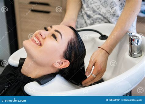 Young Brunette Girl Smiling And Enjoying Hair Washing In Hairdressing