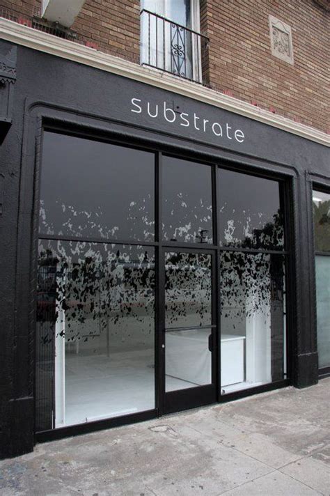 A Store Front With Black And White Paint On The Outside Wall Windows Covered In Frost