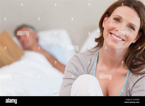Smiling Mature Woman On Bed With Reading Husband Behind Her Stock Photo Alamy