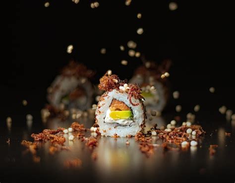 Un Sushi Con Un Fondo Negro Y Un Plato De Comida Con Salsa Roja Foto