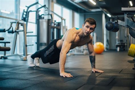 Premium Photo Strongman With Naked Torso Doing Push Ups In Gym