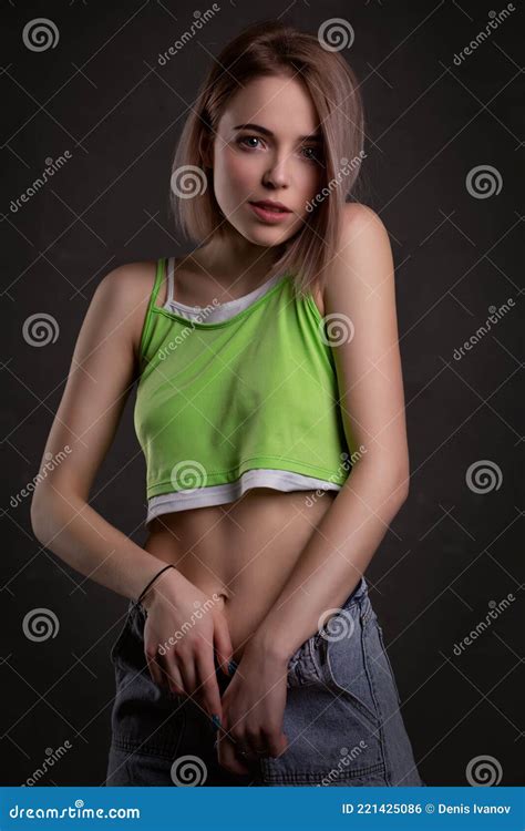 Gorgeous Blonde Girl In A Crop Top And Jeans Poses On A Dark Background Stock Photo Image Of