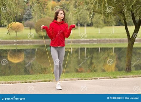 Outdoor Shot Of Focused Young Woman With Jump Rope Outdoors In Nature