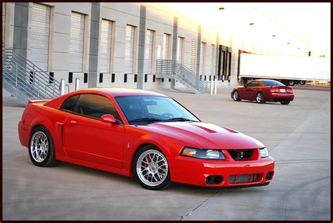 Two Red Sports Cars Parked In Front Of A Building