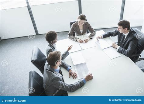 Four Business People Sitting Around A Table And Having A Business