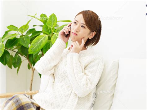 部屋でスマートフォンで電話する女性 カメラ目線 写真素材 [ 4101044 ] フォトライブラリー Photolibrary