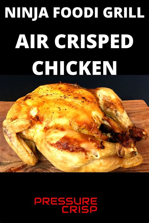 A Chicken Sitting On Top Of A Wooden Cutting Board With The Words Ninja Food Grill Air Crisped