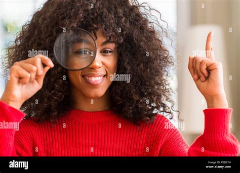 Curious African American Woman Looking Through Magnifying Glass