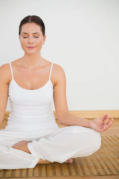 Premium Photo Smiling Brunette Sitting In Lotus Pose Looking At Camera