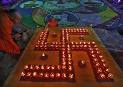 PRINT Hindu priests light oil lamps in a formation of the 'Swastika', a ...