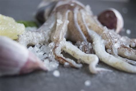 Squid Tentacles On A Slate Platter With Lemon And Garlic Stock Photo