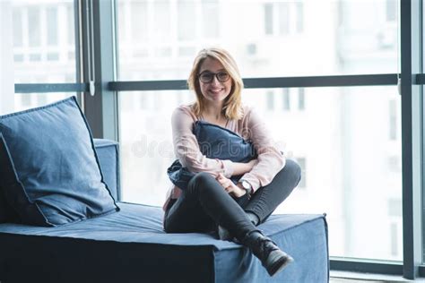 Fille S Asseyant Sur Le Sofa Avec Un Coussin Dans Ses Mains Et Sourire