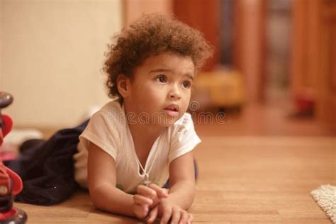 Fille Mignonne De Petit Afro américain S étendant Sur Le Plancher Avec