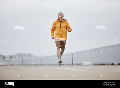 Motivational Shot Of Handsome Mature Man Running Towards Camera Wearing
