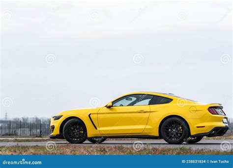 Yellow With Black Stripes Ford Mustang Muscle Car In A Parking Lot