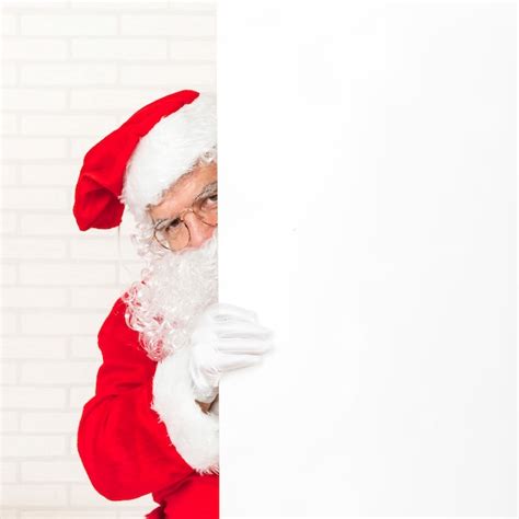 Père Noël Se Cachant Derrière Un Mur Photo Premium