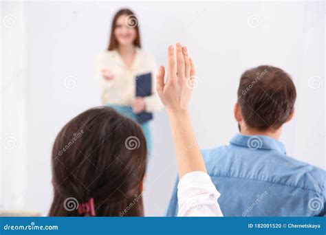 Young Woman Raising Hand To Ask Question At Business Training Closeup