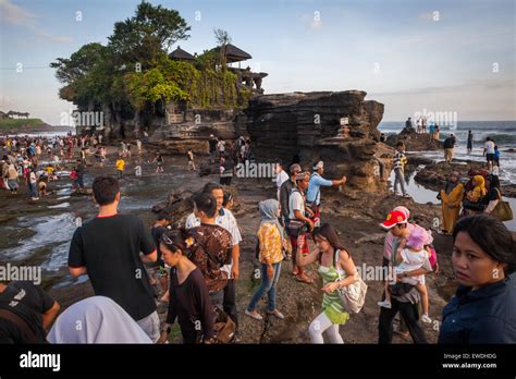 Touristes ayant du temps libre sur une plage rocheuse à Tanah Lot