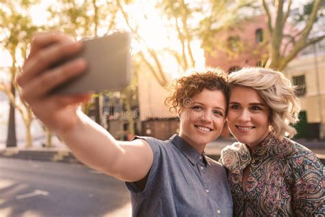 Smiling Lesbian Couple Taking Selfies Together On A City Sidewalk Stock Image Image Of Selfie