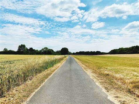 Premium Photo Road Amidst Field Against Sky