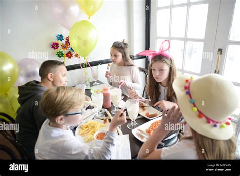 Cinq Jeunes Enfants Sont Assis Une Table En Train De Manger Les