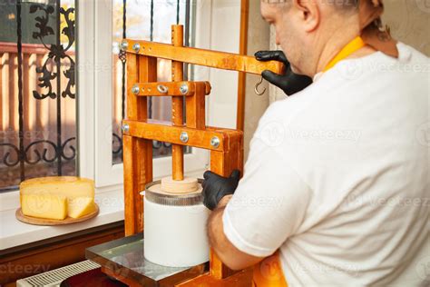 cheesemaker puts cheese under press, whey. Home production, business ...