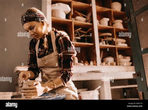 Woman Potter Making A Clay Pot On Pottery Wheel In Workshop