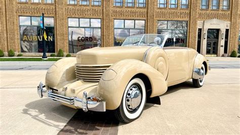 An Old Car Is Parked In Front Of A Building