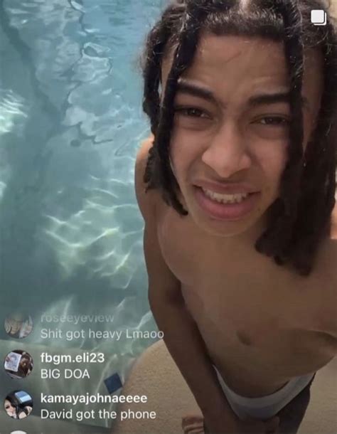 A Man With Dreadlocks Standing In Front Of A Swimming Pool Looking At