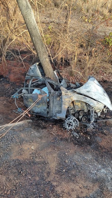 Carro pega fogo após sair da pista cair em barranco e atingir árvore