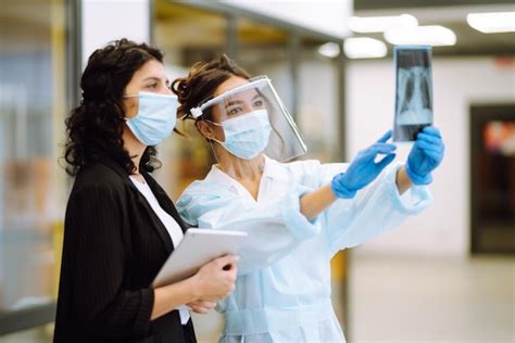 Premium Photo A Female Doctor In Visor And Protective Gloves Examines