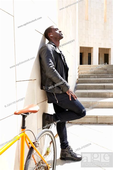 Man Standing Next To His Bike Wireless Earphones Stock Photo Picture