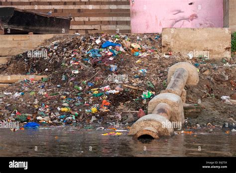 Piles Of Garbage Along The Shore And A Sewer Pipe Lands In The Ganges