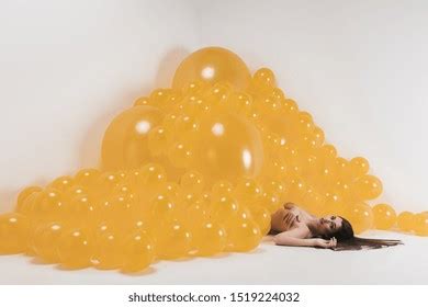 Nude Woman Between Many Yellow Balloons Stock Photo