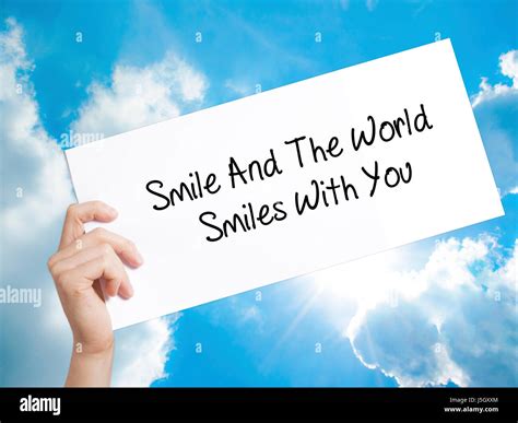 Smile And The World Smiles To You Sign On White Paper Man Hand Holding