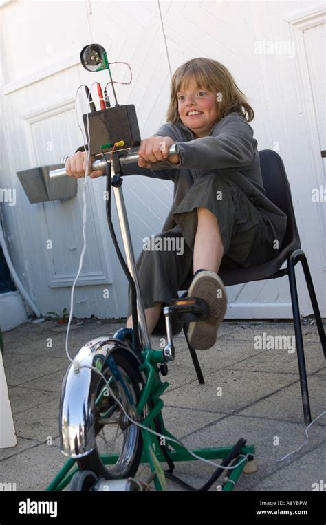 Young male child generating electricity by peddling a static bike ...