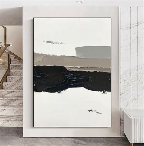 An Abstract Painting Hangs On The Wall Next To A Stair Case In A White Room