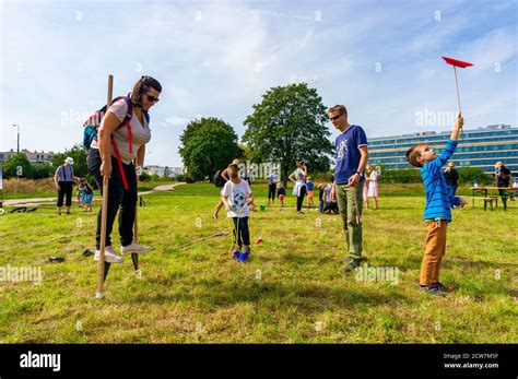 Poznan Poland Sep 13 2020 Woman With Backpack Trying To Walk On Stilts On A Green Grass