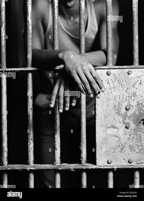 Hands through prison bars Black and White Stock Photos & Images - Alamy