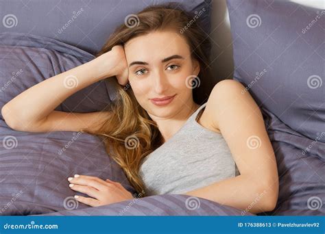 Femme Se Trouvant Sur Son Lit Regardant La Camra Avec Un Sourire Image