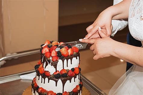 The Wedding Cake Cutting Ceremony Of A Beautiful Graceful Bride And Her