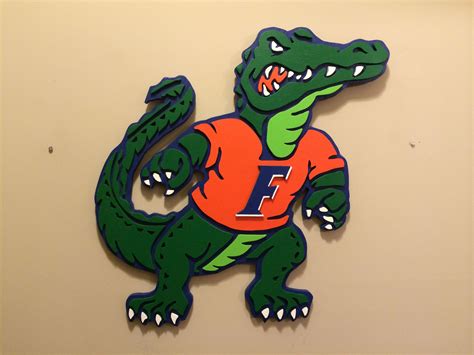 A Green And Orange Alligator With The Letter F Painted On Its Chest Is