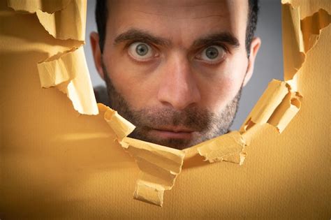 Premium Photo Man Looking Through Hole In Paper