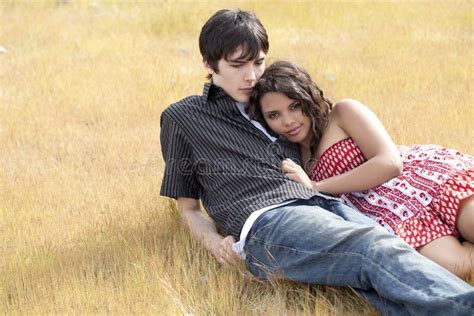 Young Teen Couple Reclining In Yellow Grass Stock Image Image Of