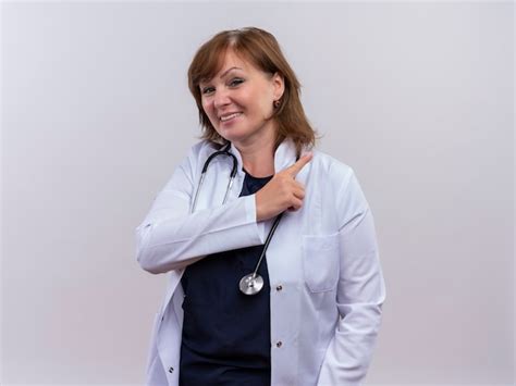 Sonriente mujer de mediana edad médico vistiendo bata médica y