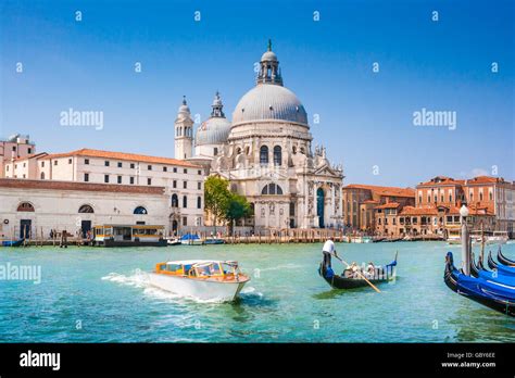 Traditional Gondola And Boat On Canal Grande With Historic Basilica Di